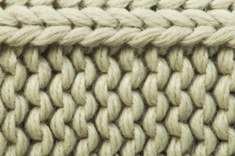 Old knit sweater background. Beige color. Studio shot