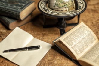Old expedition map with notebook, other books and old globe