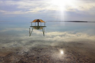 Medical beach on the Dead Sea, Israel. Round gazebo in the water near the water's edge. Cloudy sky