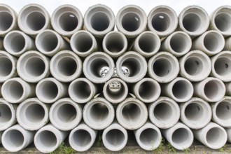 Pile of concrete sewer pipes on concrete plant grounds