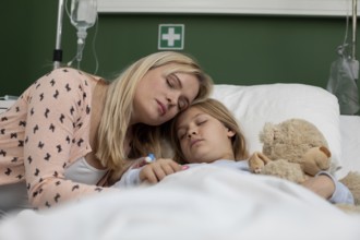 In a heartfelt scene, a loving mother is gently comforting her child, who is resting in a hospital