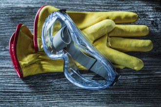 Safety leather gloves glasses on wooden board
