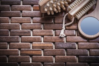 Wood massager looking-glass and peeling brush on textured wooden mat sauna concept