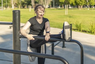 Activating muscles: Mature woman warming up outdoors in an urban park