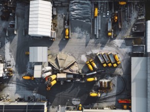 Aerial view in industrial area, directly above concrete factory, firm with lots of heavy machinery