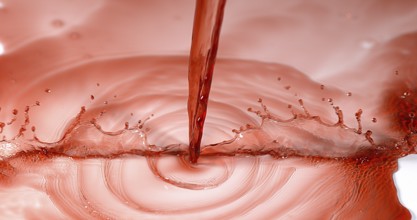 Red Wine being poured against White Background