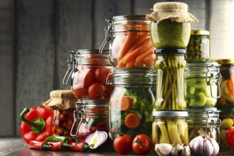 Jars with marinated food and organic raw vegetables