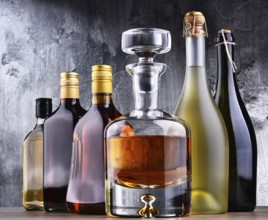 Composition with carafe and bottles of assorted alcoholic beverages