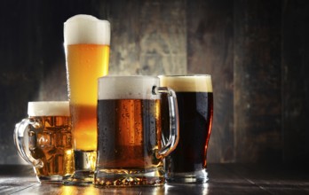 Four glassed of beer on wooden background