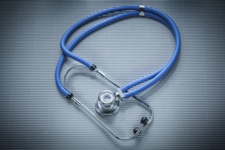 Medical stethoscope on striped background, view from above