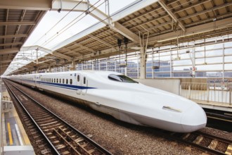 A Shinkansen high-speed bullet train pulling into a train station in Japan