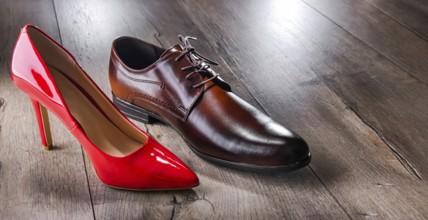 Composition with a high heel women's shoe and a men's shoe