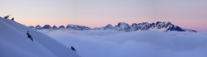 panorama winter mountain landscape at sunset with snow slope and cloud cover in the foreground in