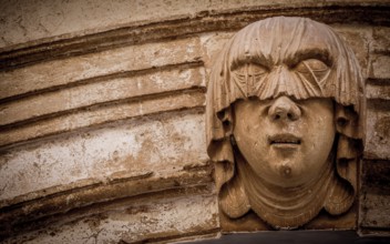 Gothic detail. Young woman portrait at the entrance of a 200 years old building in Ciutadella town,