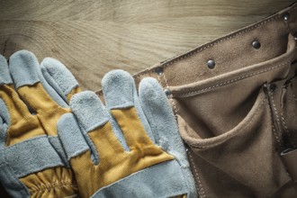 Leather tool belt Safety gloves on wooden board