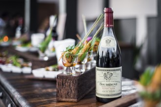 Bottle of red bourgogne wine at oudoor party bar counter