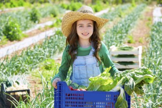 Litte kid farmer girl in vegetables harvest at orchard