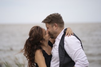 Lovers hug and kiss on a beach