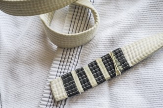 White belt of Brazilian Jiu-Jitsu with four degrees, on top of the kimono
