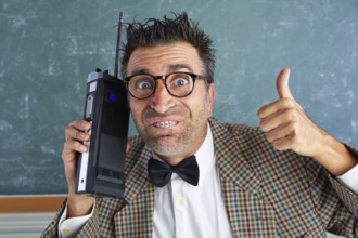 Nerd silly private investigator with retro walkie talkie on teacher balckboard