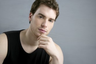 Young man portrait posing looking camera over gray background