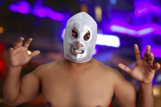 Mexican wrestling mask silver fighter with aggresive gesture night blurred lights