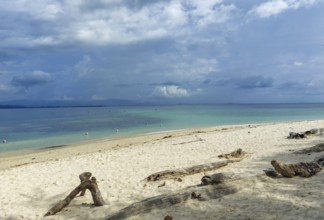 A fine, beige sandy beach on Borneo Malaysia . Intense clouds over a turquoise-coloured sea