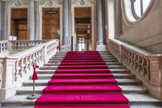 Turin, Italy, Circa January 2022: red carpet in Royal Palace, luxury elegant marble stairway,