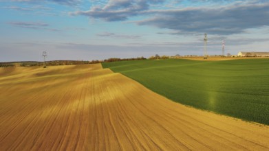 Aerial view of amazing green wavy hills with agricultural fields in evening spring. South Moravia