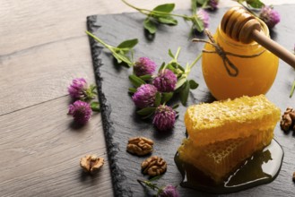 Honeycomb on slate tray with honey and nuts on kitchen table