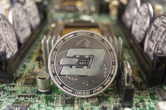 Dash coin close-up on a computer circuit motherboard as a blockchain technology payment network.