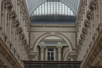 Dark historic interior with glass roof and ornate arches and columns, den haag, the netherlands