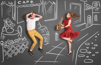 Love story concept of a romantic couple against chalk drawings background. Woman playing the