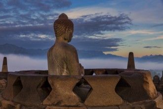 Buddha statue at sunrise, Borobudur temple complex, Borobudur, Yogyakarta, Java, Indonesia, Asia