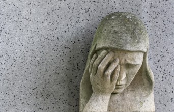 A sad Madonna in the Barbarafriedhof cemetery in Linz, Austria, Europe