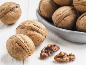 Inshell walnut on white wooden background