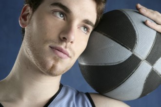Basketball young man basket player portrait over blue studio background