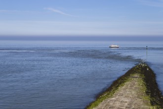 The photo shows a jetty with a survey vessel by day on the island of Baltrum