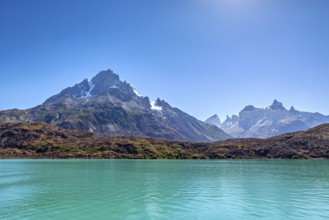 Majestic mountains with rugged peaks in front of a clear turquoise-coloured lake, the landscape of