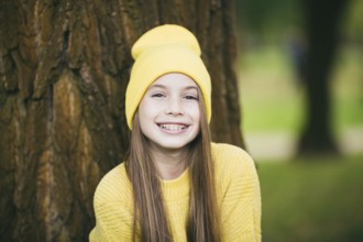 Cute teenage girl with braces smiling happily dressed in bright yellow clothes outdoors. Cute and