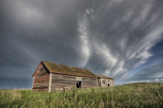 Abandoned Farm with storm clouds in the Canadian Prairie