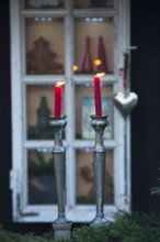 Two red candles in front of a decorated window and Christmas decorations, borken, münsterland,