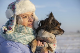 Close-up on the face of a girl looking towards the sun. The girl, wearing a cap and jacket, is
