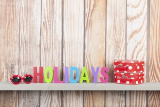 Wooden background for holidays with suitcases and sunglasses
