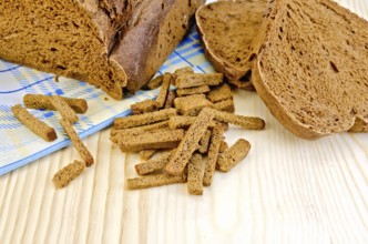 Rye homemade bread, crackers, blue cloth on a background of wooden boards