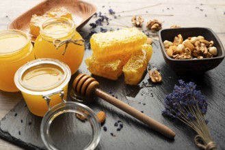 Honeycomb on slate tray with honey and nuts on kitchen table, food photography, food photography