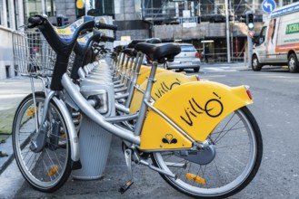 Belgium, 02 15 2019: Villo station with a row of yellow cycles for sharing and renting in the city,