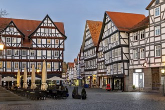 Illuminated half-timbered buildings in the evening mood on a market square, The old town centre of
