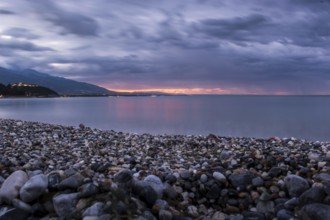 Beautiful seascape, amazing view of pebble coastline in mild sunset light, romantic evening on the