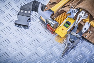Collection of construction tooling in tool belt on corrugated metal background maintenance concept